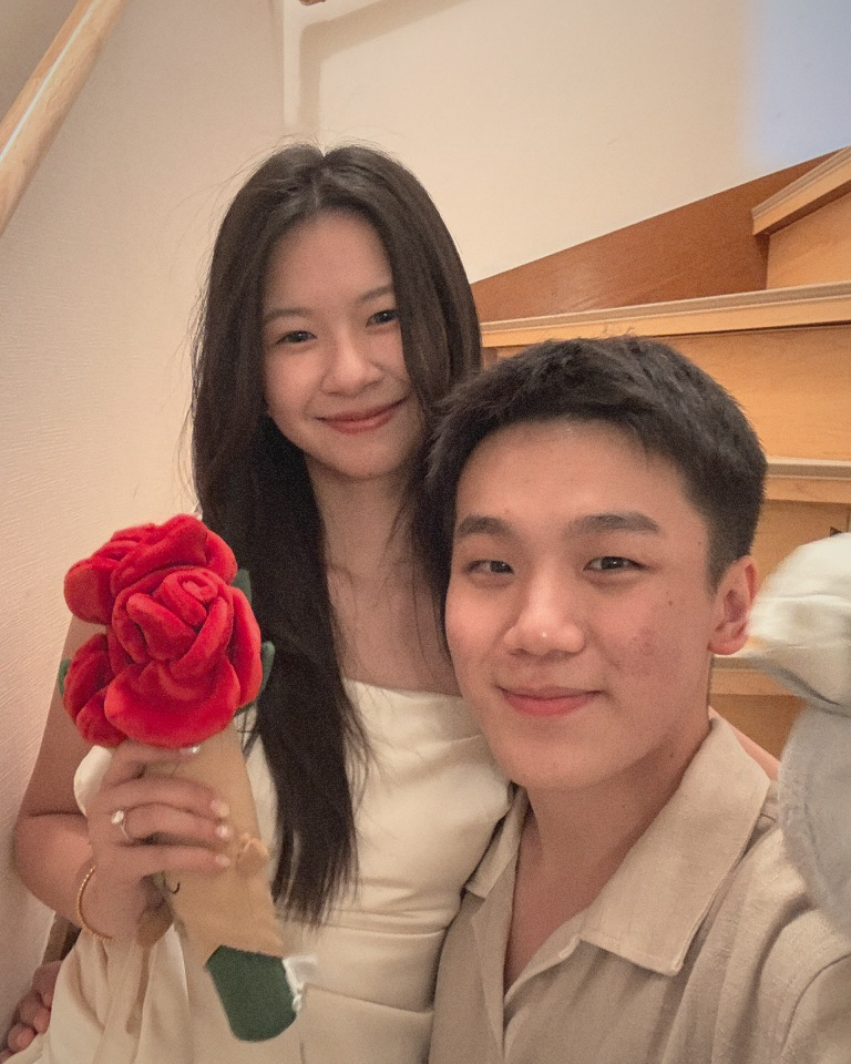 KC and Cynthia smiling together with a red rose